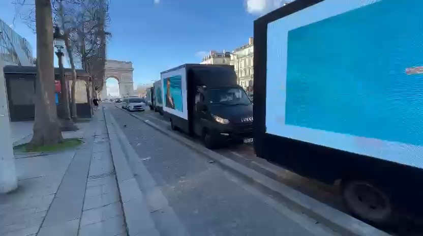 LED-Werbetrucks in Reihe auf den Champs-Élysées nahe dem Arc de Triomphe